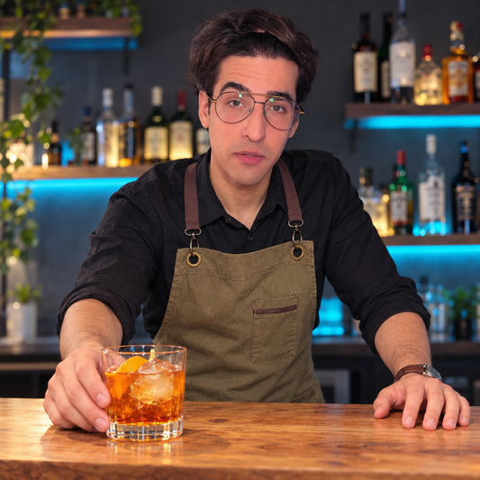Mi Alter Edu con el delantal verde oliva y una bebida en la barra. Imagen generada con IA a partir de referencias recientes.